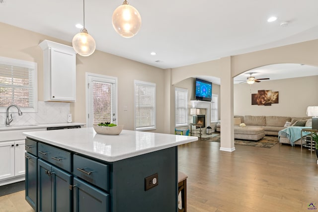 kitchen featuring sink, white cabinetry, pendant lighting, and a kitchen island