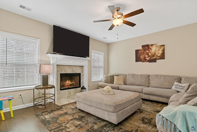 living room featuring ceiling fan, dark wood-type flooring, and a high end fireplace