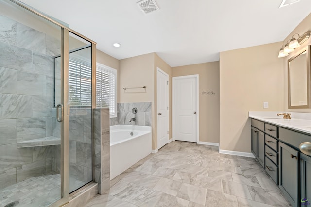 bathroom with vanity and shower with separate bathtub