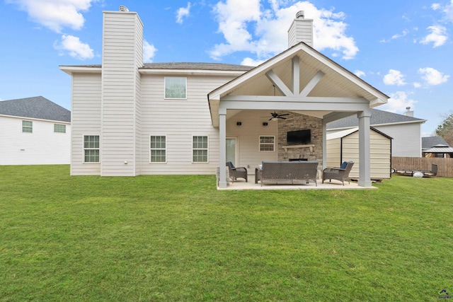 back of house with a patio area, a shed, an outdoor living space with a fireplace, ceiling fan, and a yard