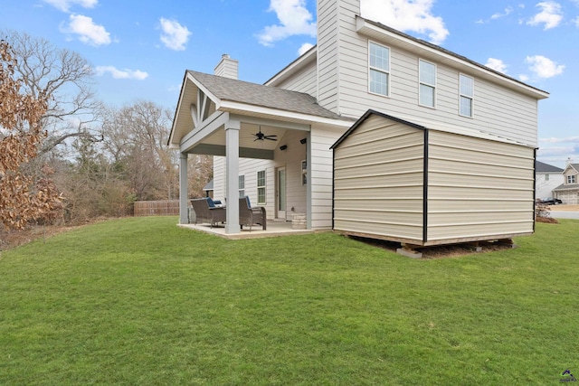 rear view of property with ceiling fan, a patio, and a yard