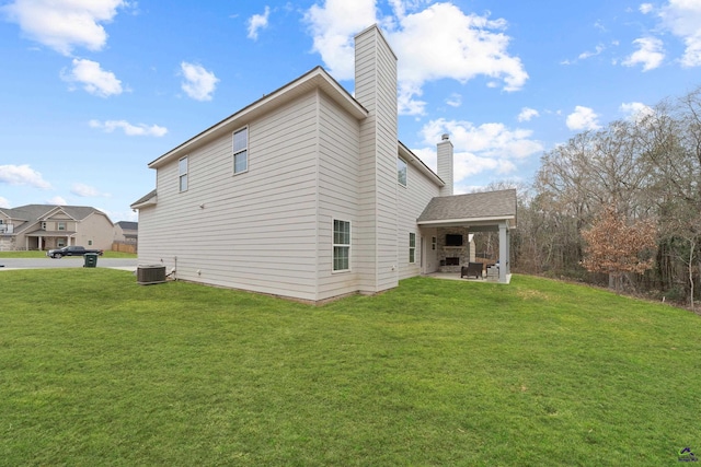 view of side of home featuring a patio, central AC unit, and a lawn