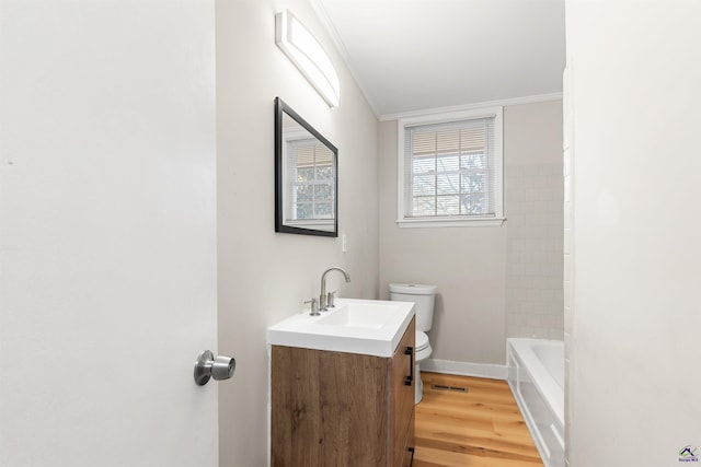 bathroom with vanity, toilet, ornamental molding, and hardwood / wood-style floors