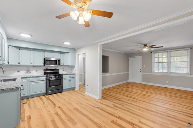 kitchen featuring sink, ornamental molding, light wood-type flooring, and stainless steel appliances