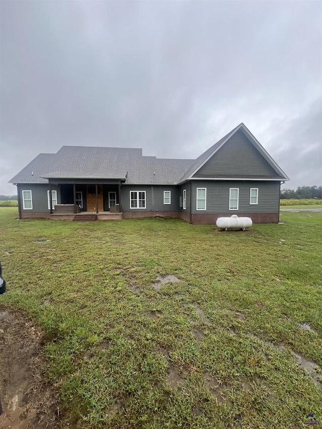 rear view of property with a lawn