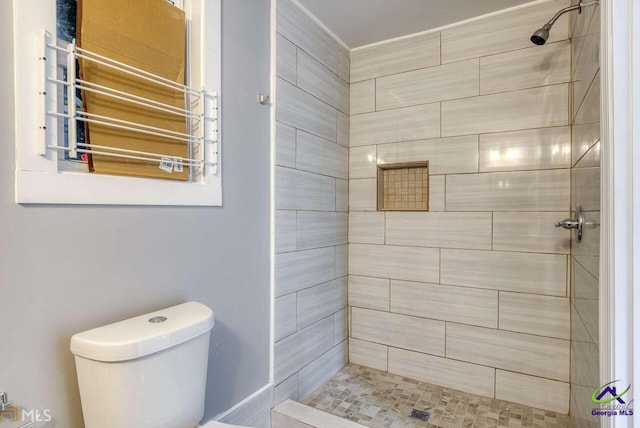 bathroom with toilet and a tile shower