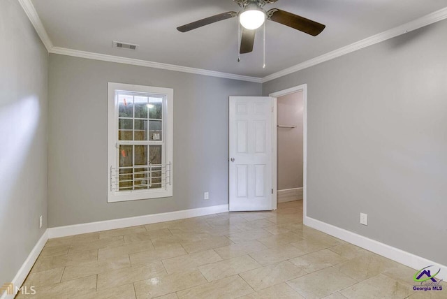 tiled empty room featuring crown molding and ceiling fan