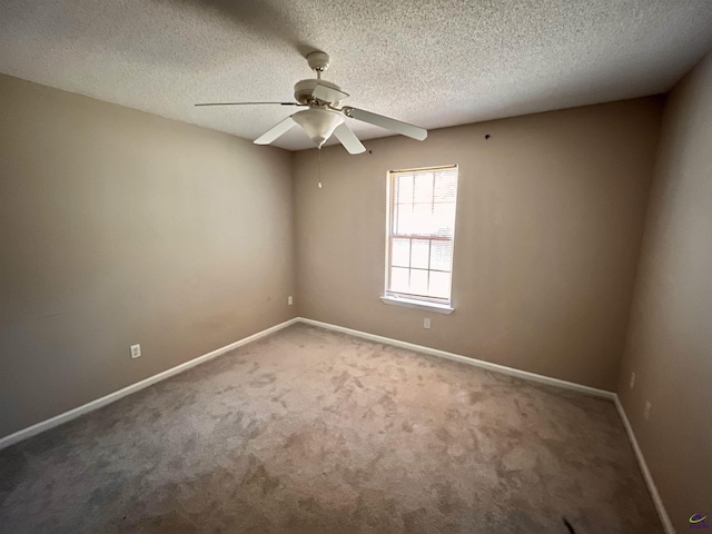 carpeted empty room featuring ceiling fan and a textured ceiling