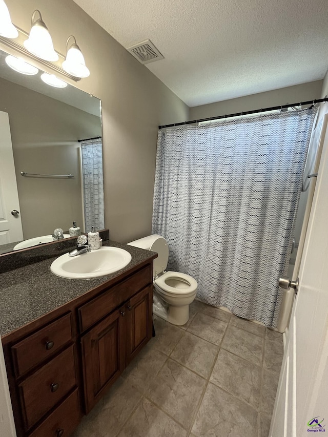 bathroom featuring vanity, toilet, and a textured ceiling