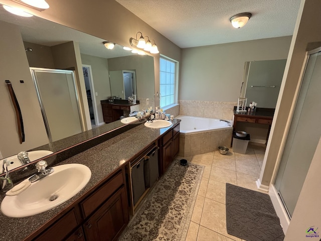 bathroom featuring a textured ceiling, tile patterned floors, vanity, and shower with separate bathtub