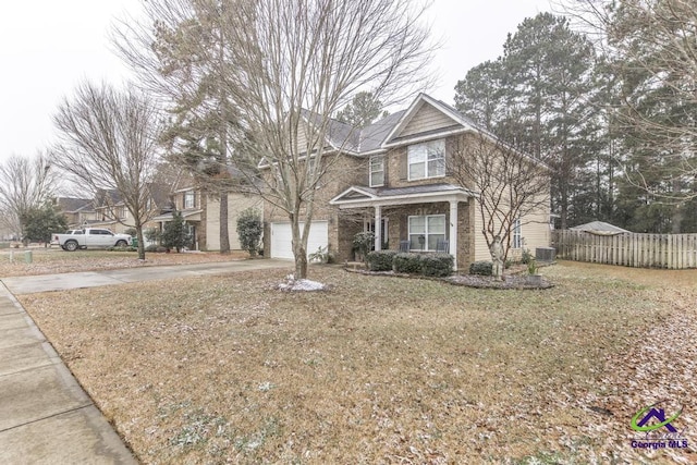 front of property with covered porch, a front yard, central air condition unit, and a garage