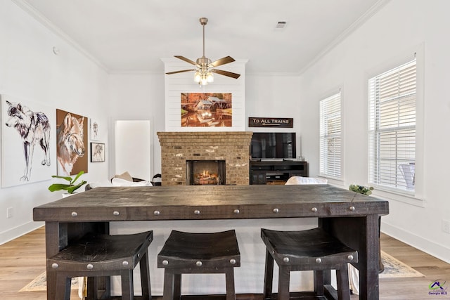 kitchen with crown molding, a brick fireplace, and a wealth of natural light