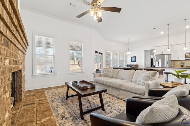 living room featuring ornamental molding, ceiling fan, a fireplace, and dark hardwood / wood-style flooring