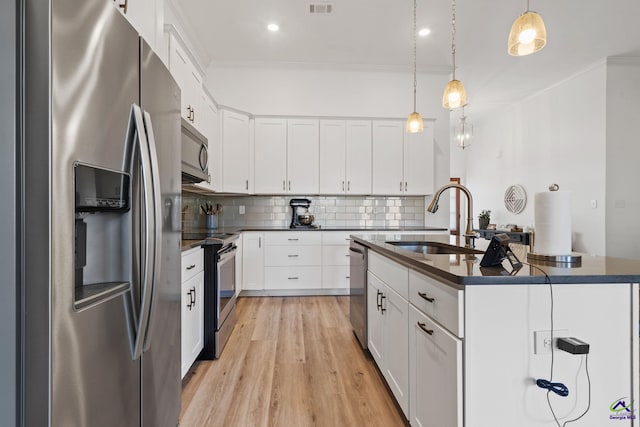 kitchen with white cabinetry, appliances with stainless steel finishes, decorative light fixtures, and crown molding