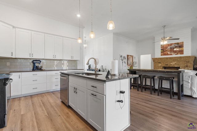 kitchen with white cabinetry, sink, and a kitchen island with sink