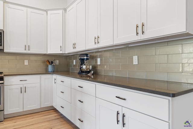 kitchen featuring light hardwood / wood-style floors, decorative backsplash, and white cabinets