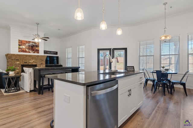 kitchen featuring pendant lighting, sink, dishwasher, white cabinets, and a kitchen island