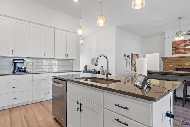 kitchen with sink, white cabinetry, a center island with sink, dishwasher, and backsplash