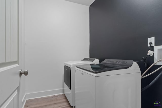 washroom featuring washing machine and dryer and light hardwood / wood-style floors