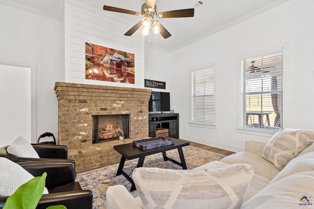 living room featuring crown molding, hardwood / wood-style floors, ceiling fan, and a fireplace