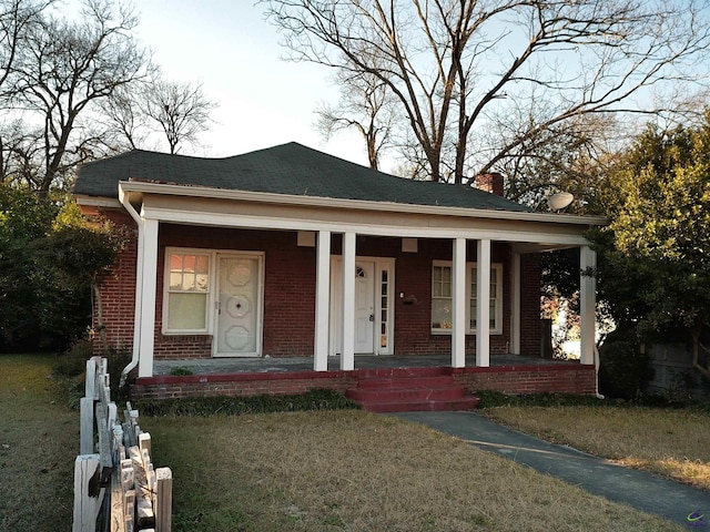 bungalow-style home with a front lawn and covered porch