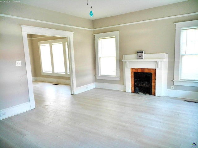 unfurnished living room with a fireplace and light hardwood / wood-style floors