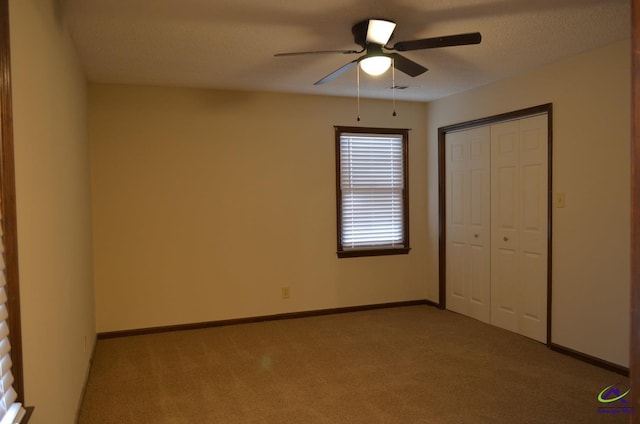 unfurnished bedroom with ceiling fan, light colored carpet, and a closet