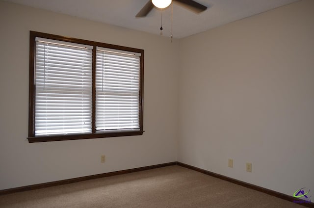 carpeted spare room featuring ceiling fan