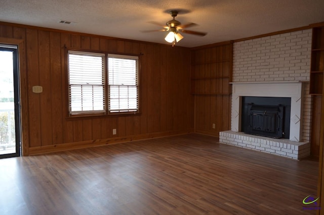 unfurnished living room featuring dark hardwood / wood-style floors, crown molding, a healthy amount of sunlight, and a textured ceiling