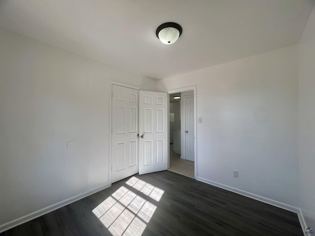 unfurnished bedroom featuring dark hardwood / wood-style floors and a closet