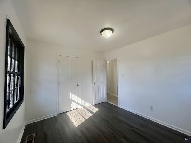 unfurnished bedroom with dark hardwood / wood-style floors