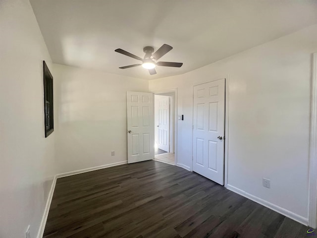 unfurnished bedroom featuring dark wood-type flooring and ceiling fan