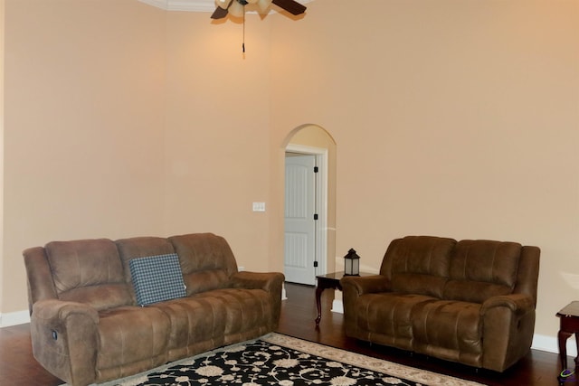 living room featuring crown molding, dark wood-type flooring, and ceiling fan