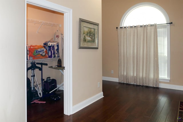 corridor with dark hardwood / wood-style flooring