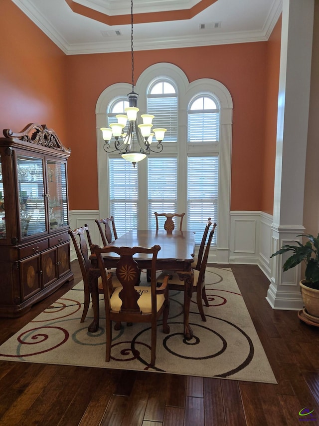 dining space featuring ornamental molding, dark hardwood / wood-style floors, a tray ceiling, and a notable chandelier