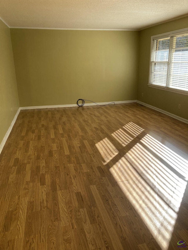 empty room featuring dark wood-type flooring and a textured ceiling