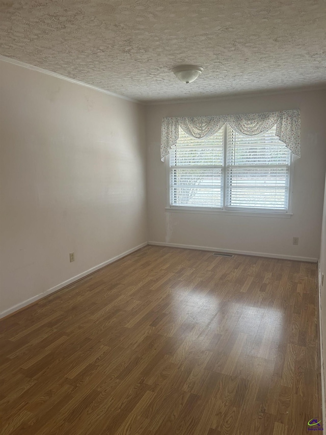 spare room with dark hardwood / wood-style flooring and a textured ceiling