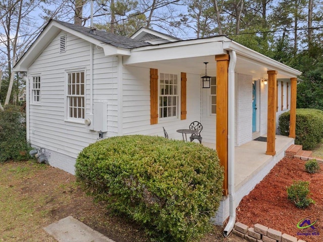 view of side of home featuring covered porch