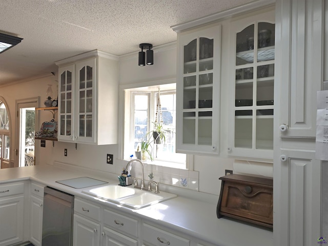 kitchen featuring glass insert cabinets, ornamental molding, white cabinets, a sink, and dishwasher