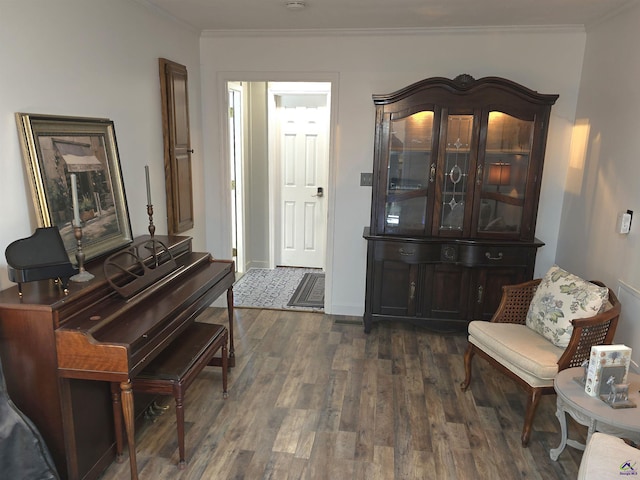 sitting room featuring ornamental molding, dark wood-type flooring, and baseboards