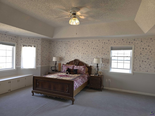 bedroom with ceiling fan, a raised ceiling, and carpet floors