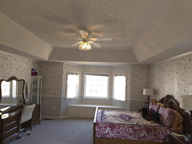 bedroom featuring ceiling fan, carpet flooring, a raised ceiling, and a textured ceiling