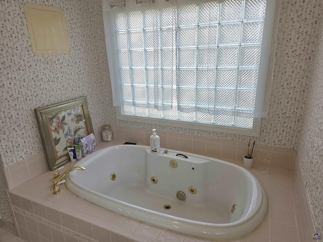 bathroom with wallpapered walls, plenty of natural light, and a tub with jets