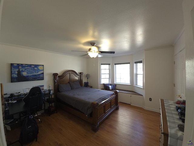 bedroom with ceiling fan, ornamental molding, and wood finished floors