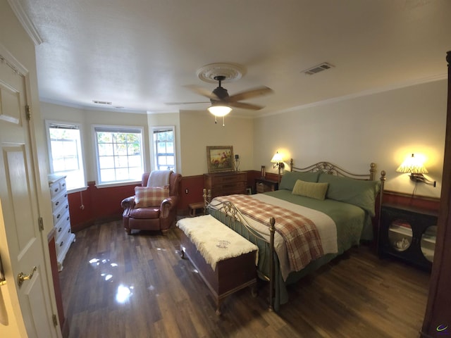 bedroom with crown molding, ceiling fan, and dark hardwood / wood-style flooring