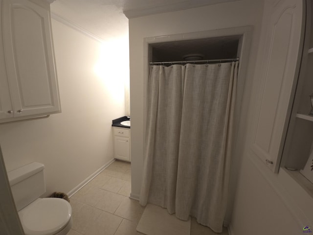 full bathroom with baseboards, toilet, tile patterned flooring, crown molding, and vanity