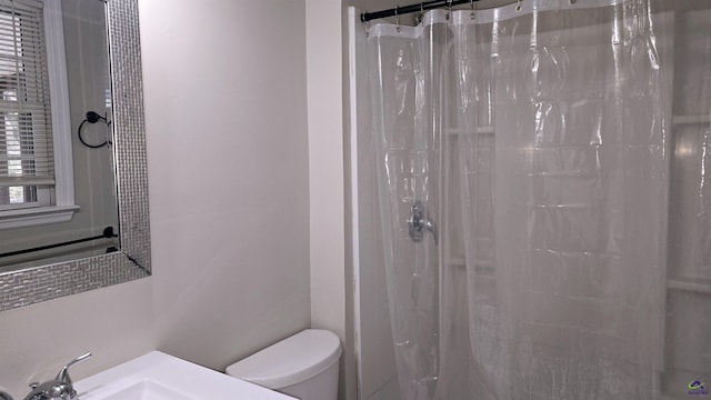 bathroom with sink, toilet, and a shower with shower curtain