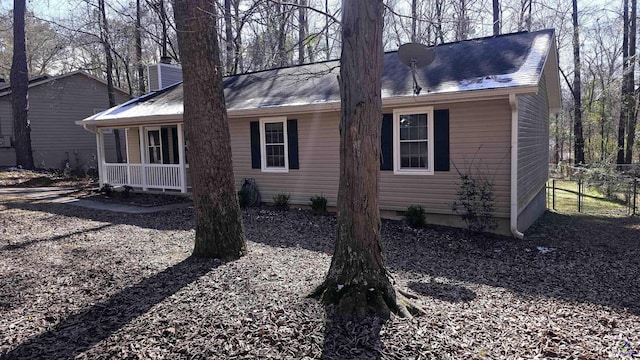 view of side of home featuring covered porch