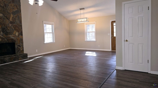 unfurnished living room with dark hardwood / wood-style flooring, a fireplace, ceiling fan, and vaulted ceiling