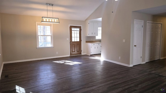 entrance foyer featuring lofted ceiling and dark hardwood / wood-style flooring